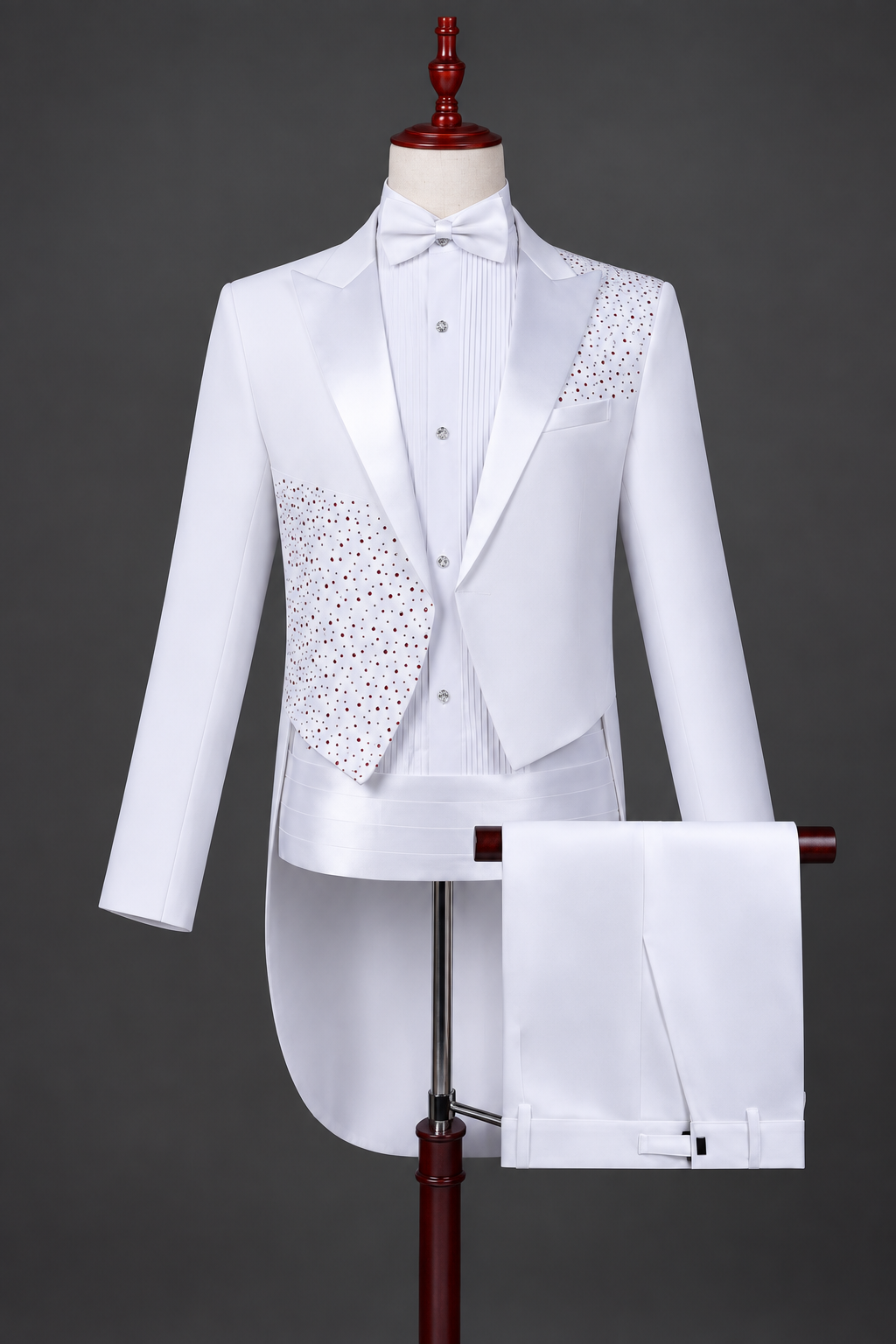 White embellished men's tuxedo with bow tie displayed on a mannequin against a charcoal studio background